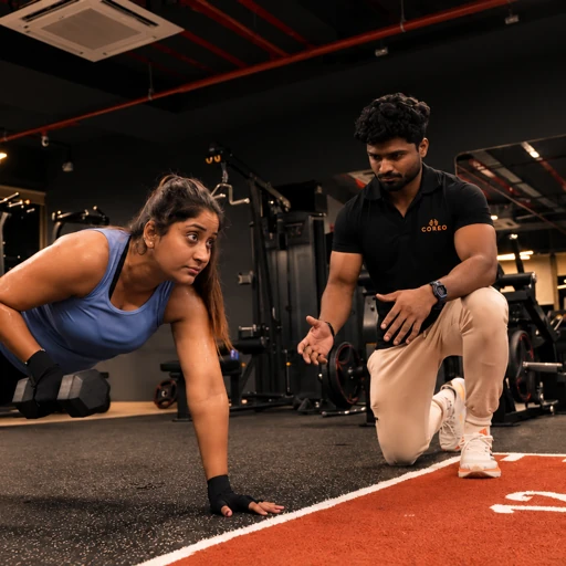 A coach helping a gym member train.