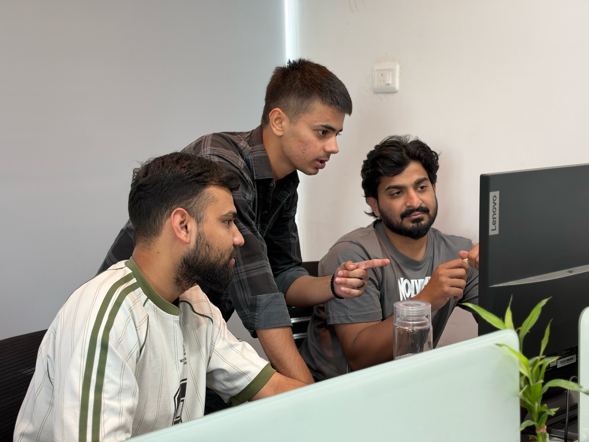 Three FitWay team members collaborating at a computer.
